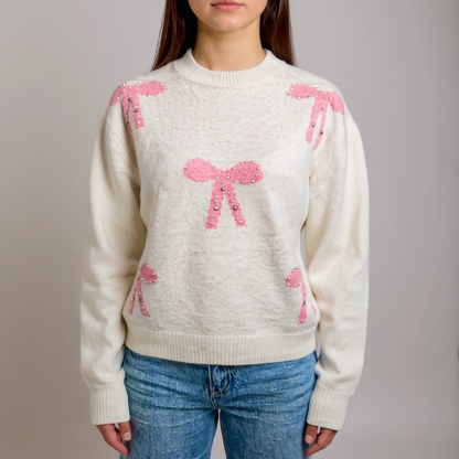 Verspielter Damen-Pullover in Creme mit rosa Schleifen – weicher Strick für feminine Casual-Looks. Perfekt kombinierbar mit Jeans oder Röcken. Exklusiv bei CasinoFashion in Winterthur.